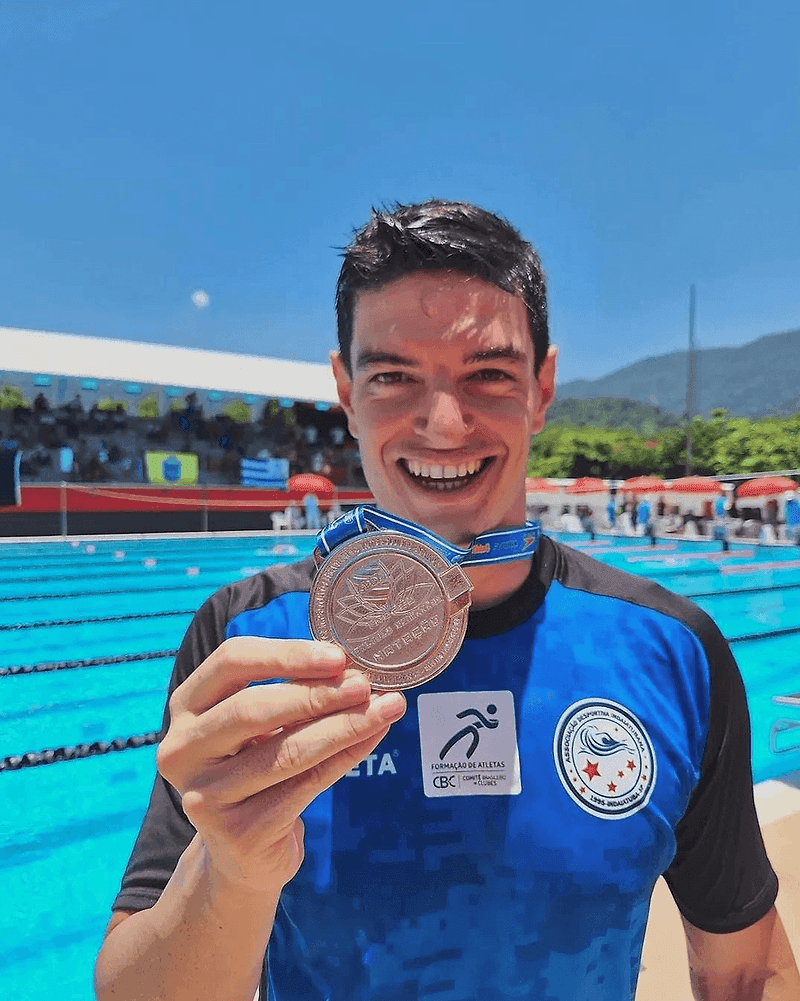 Conrado Lino com a medalha, na borda da piscina